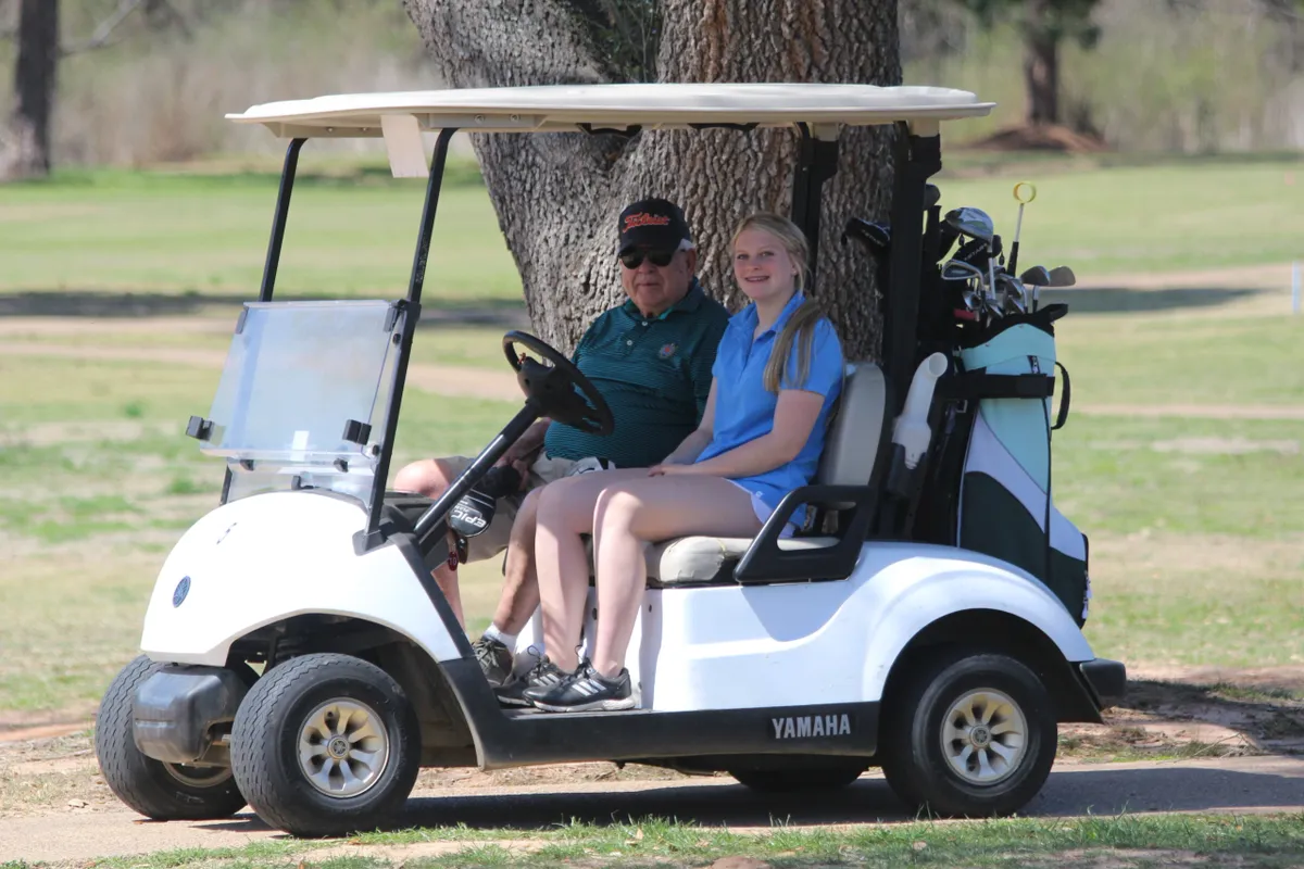a father and daughter driving golf cart